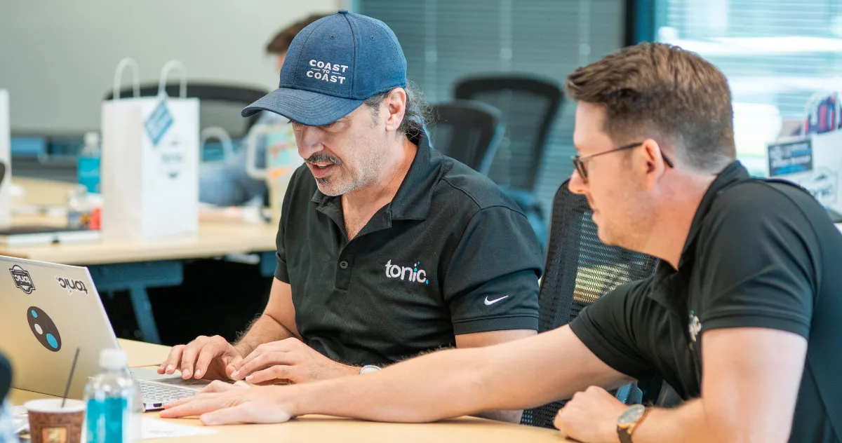 A Tonic POS partner provides hands-on training to a restaurant owner, demonstrating the personalized support offered through the program.